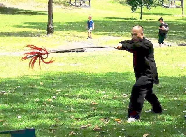 Master Stephen Lin performing a traditional spear form outdoors